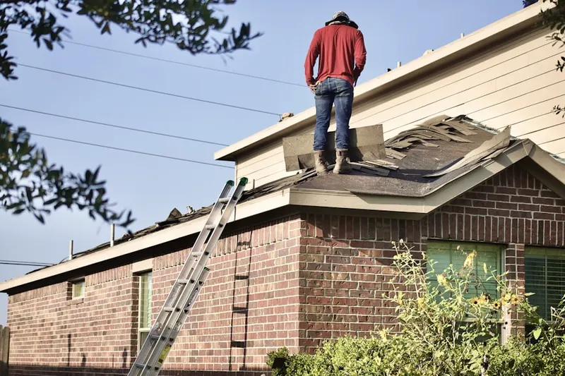 Professional roofer working on a residential roof in Bellport